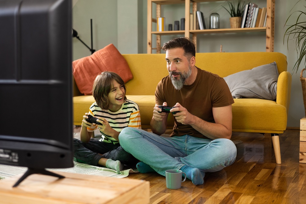 Dad and older boy having fun playing games on a games console together