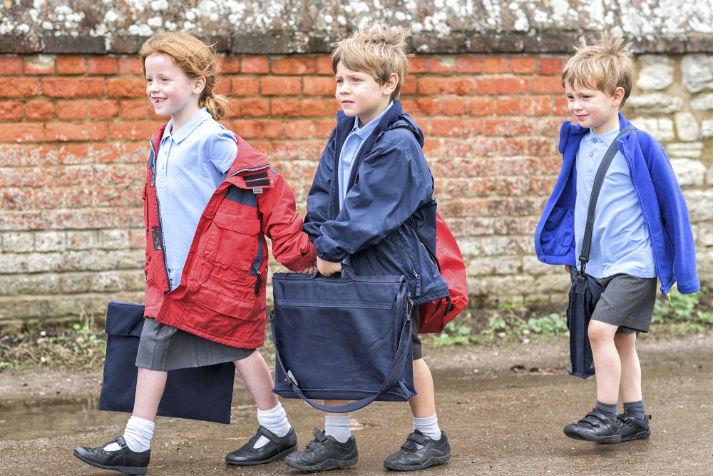 Triplets heading off to school carrying school bags
