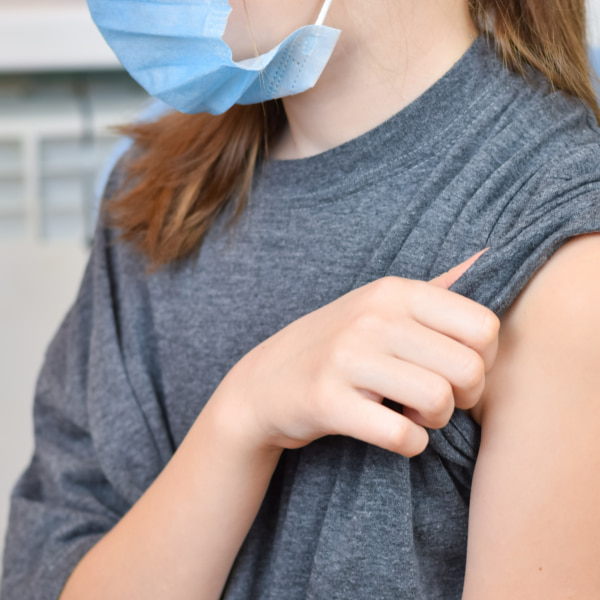 Teen rolling up their sleeve to be vaccinated