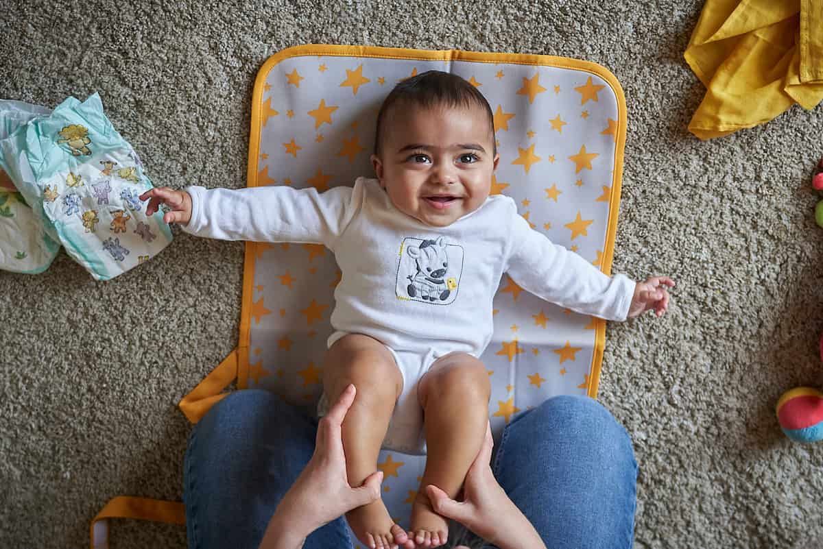 Smiling baby lying on their back on a playmat
