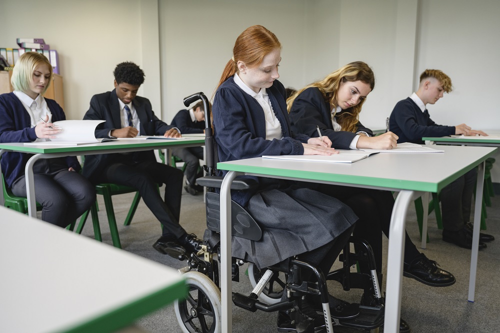Teens doing an exam, one is in a wheelchair