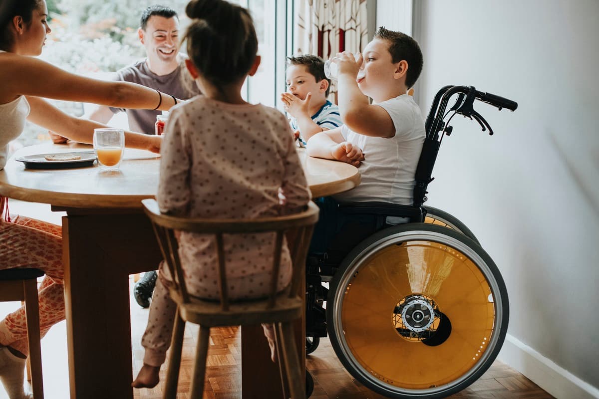 Family eating together, one child is in a wheelchair