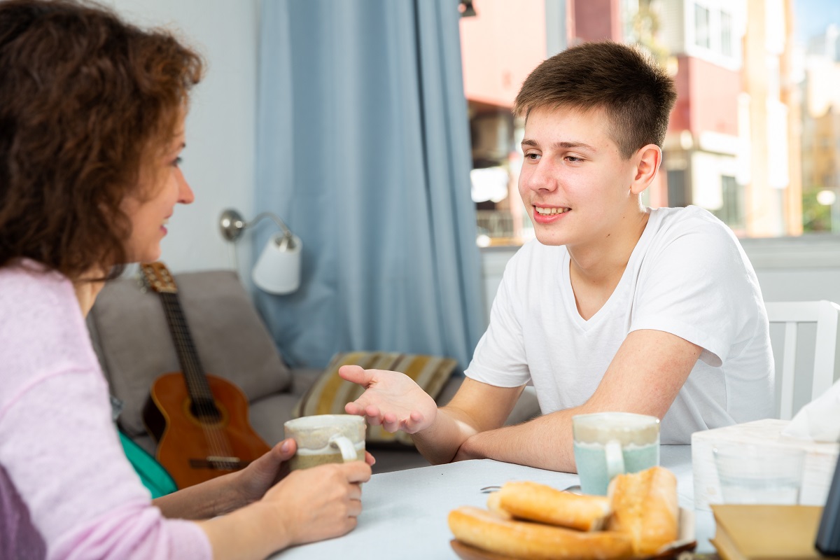 Mother and teen boy chatting over breakfast