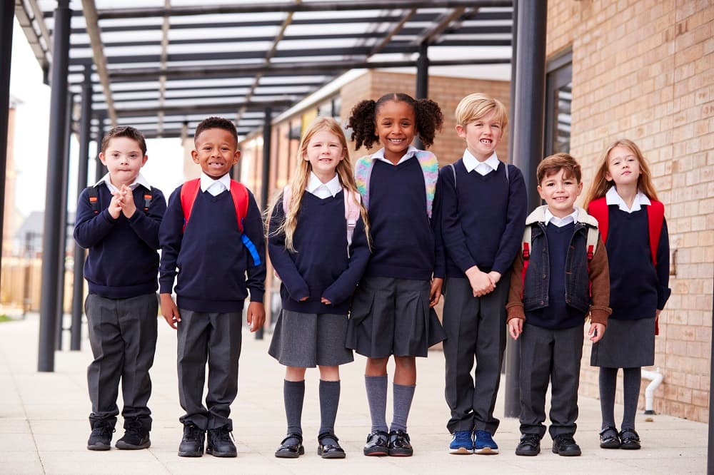 School kids in uniform standing outside their school