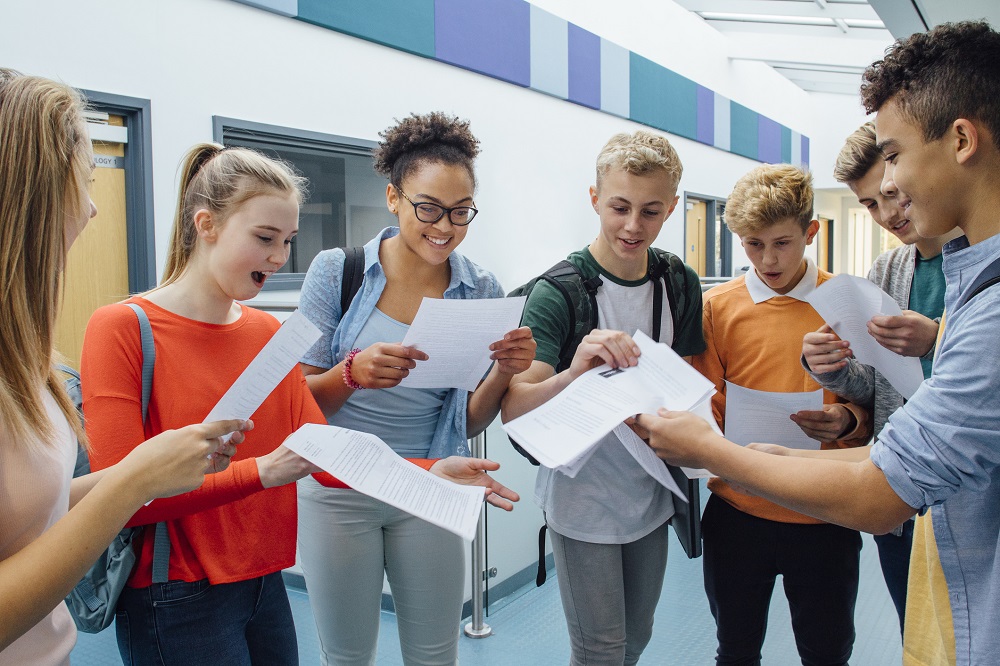 Teenage students getting their exam results in school