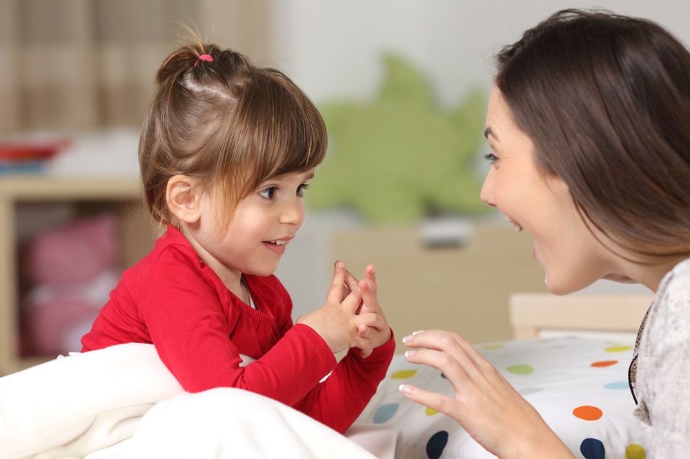 Mum and young girl talking and smiling