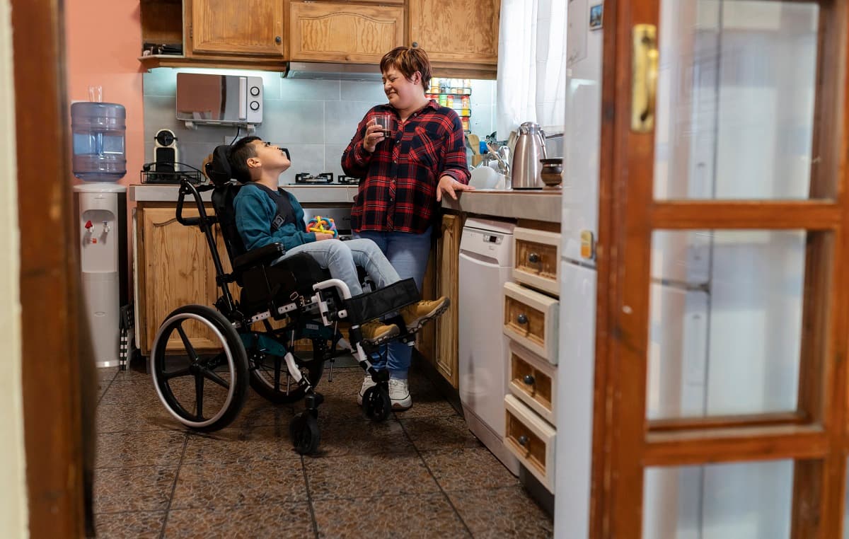 Mum and disabled child talking in the kitchen