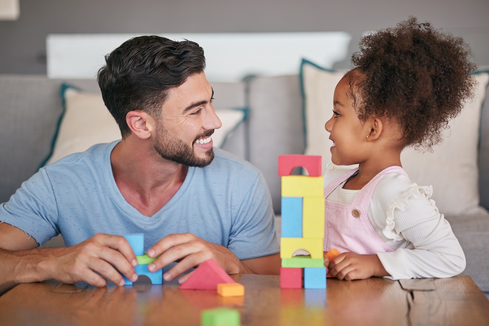 Dad and young girl playing with blocks