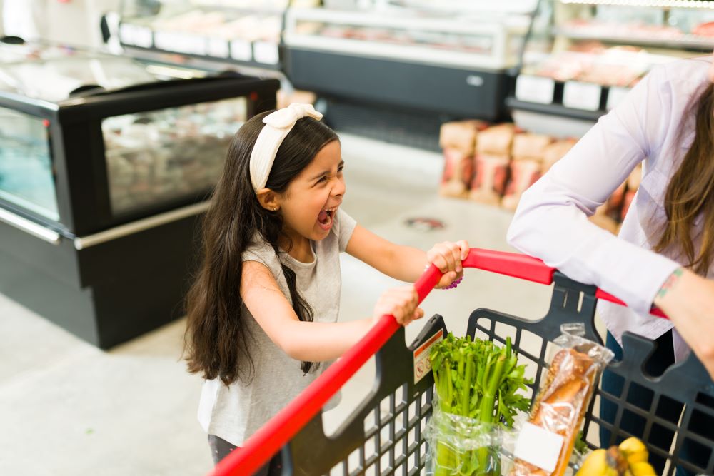 Young girl having a strop in a supermarket.