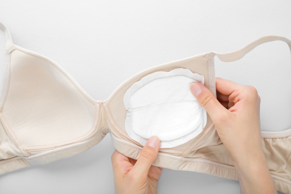 Breast pad being inserted into a bra.