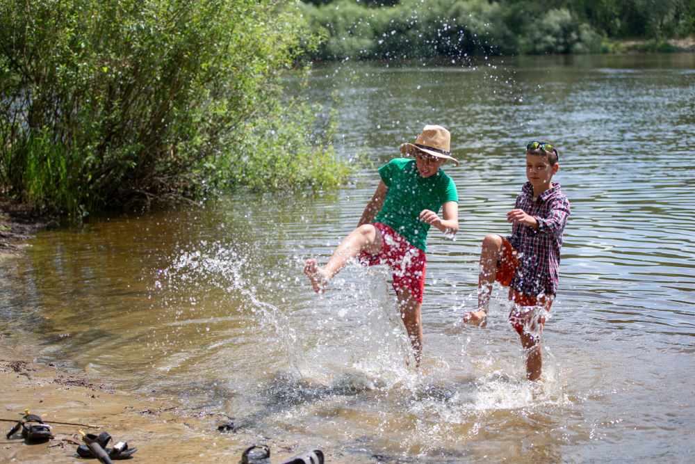 Boys splashing in a river.