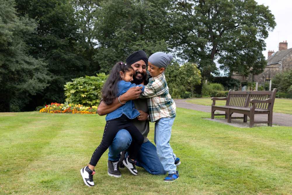 Dad and young children playing in the park.