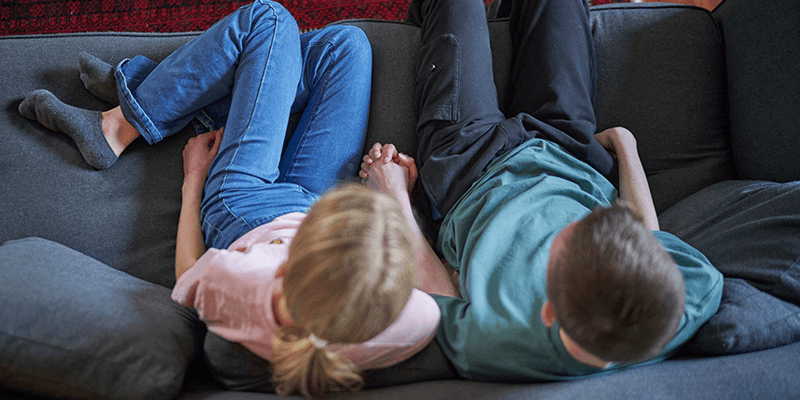 teen-girl-and-boy-sitting-on-couch-together-banner
