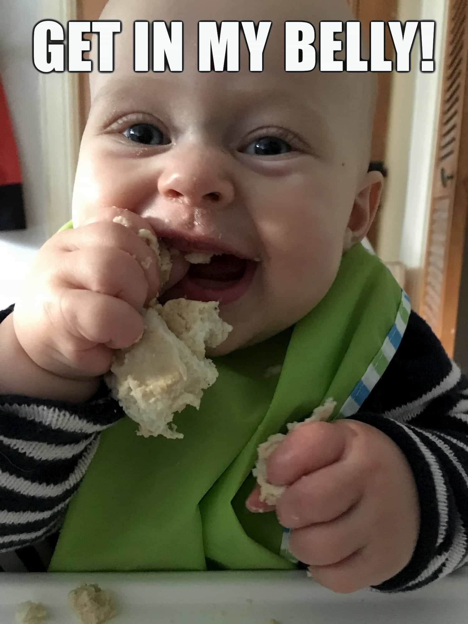 baby happily eating bread with caption Get in my Belly!