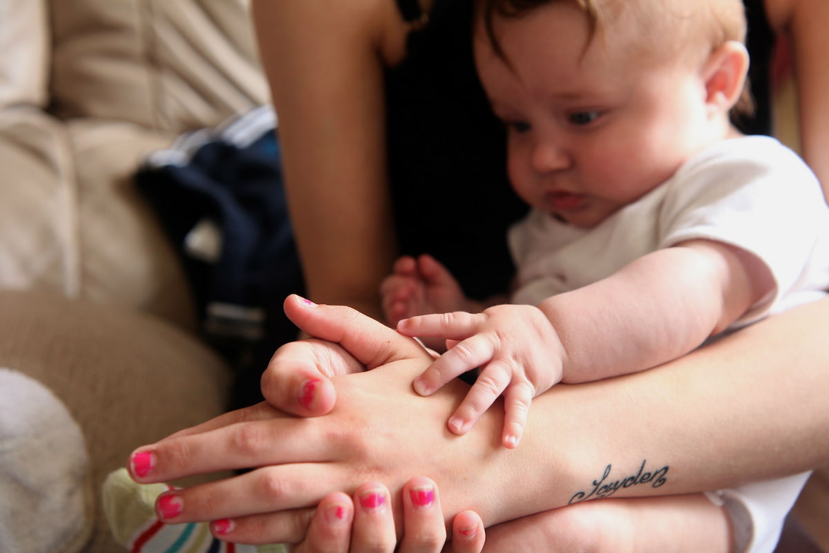Photo of a baby holding mum's hand