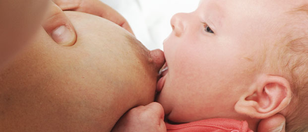 Photo of a baby suckling on its mothers nipple