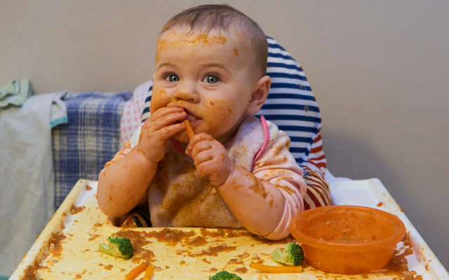 a baby in their highchair eating food