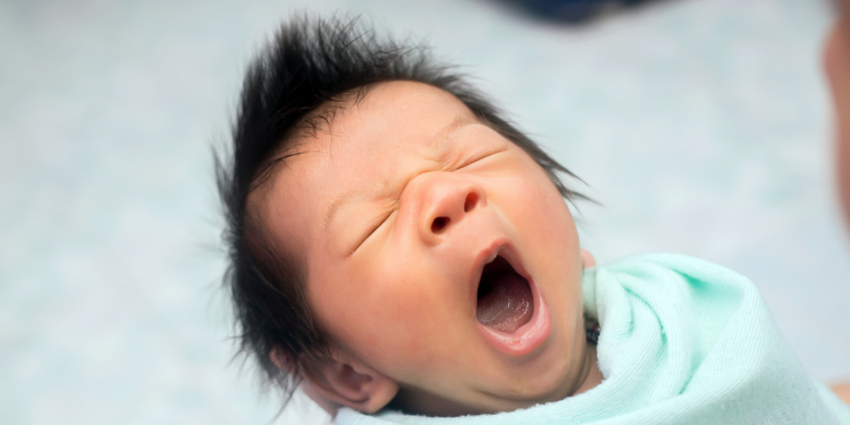 Photo of a young baby yawning