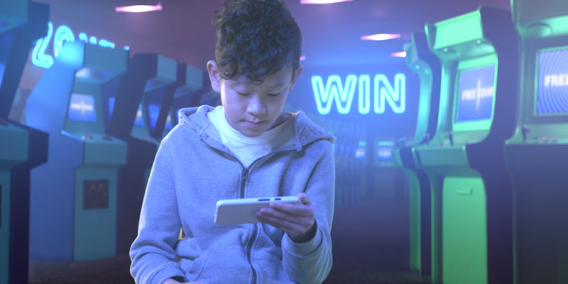 boy-looking-at-phone-in-arcade-banner
