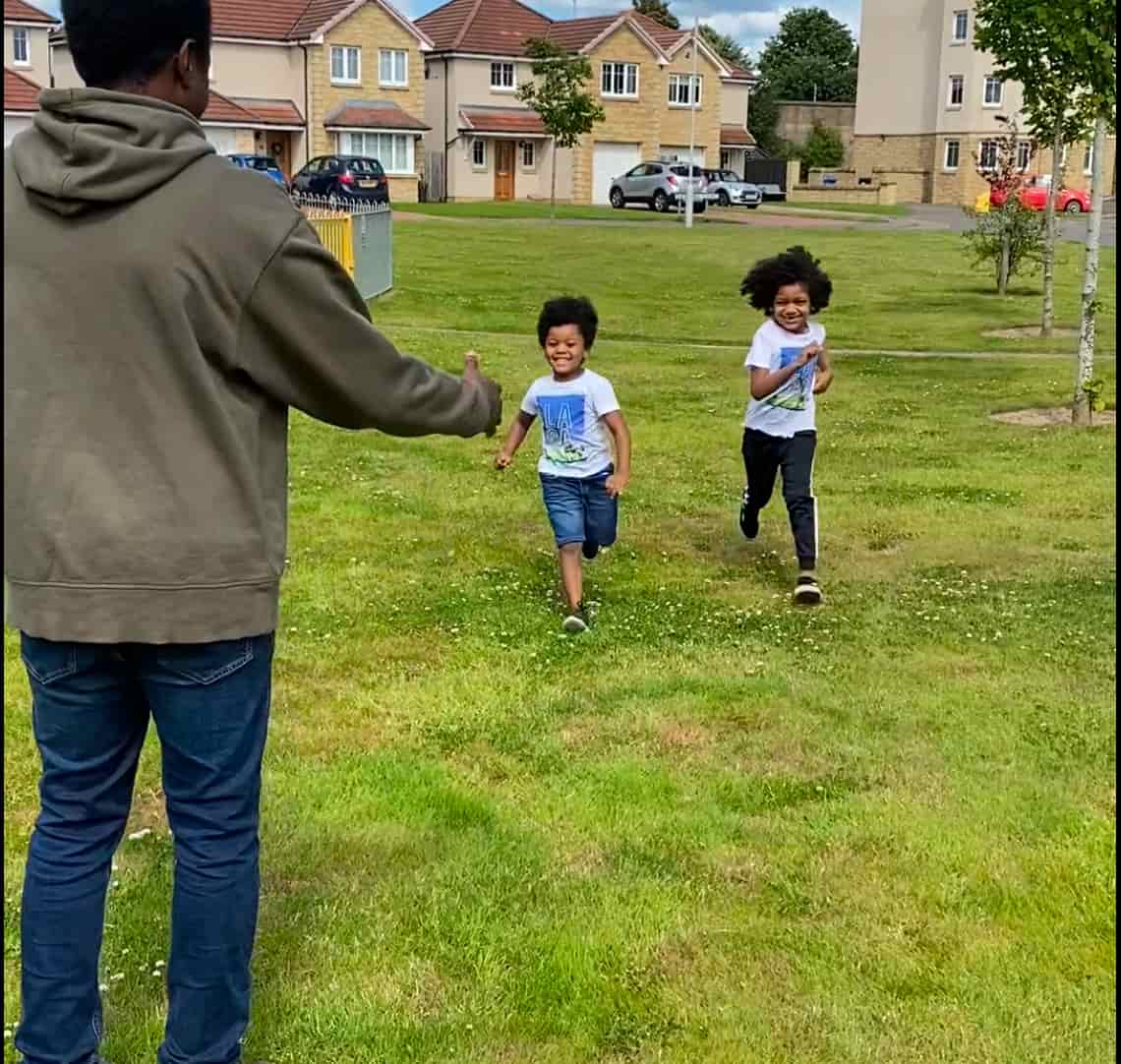 Photo of boys running towards dad 
