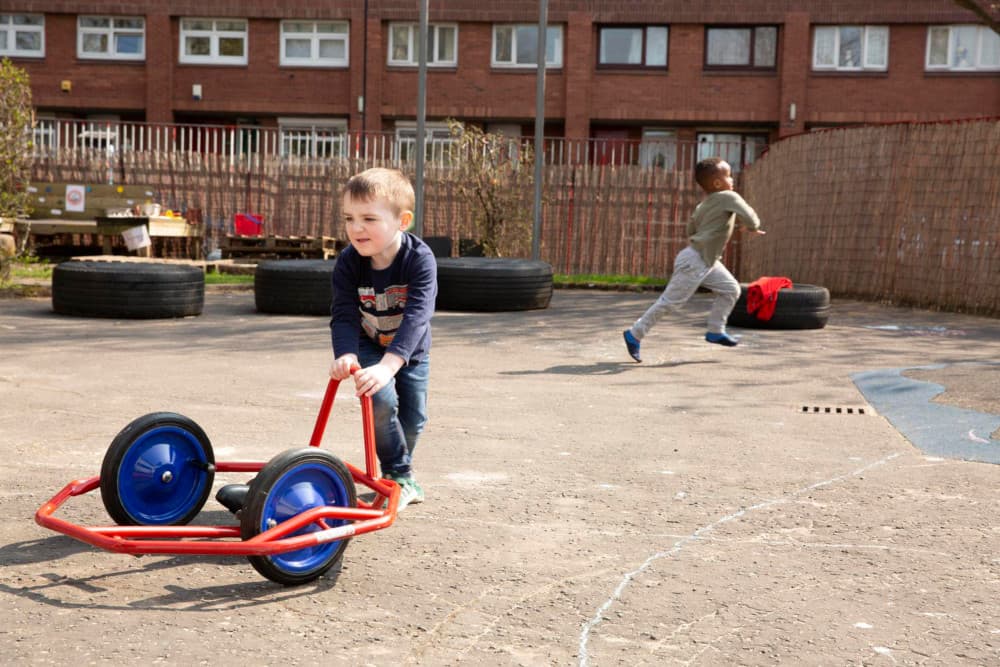 Image of two children playing in a playground outside.