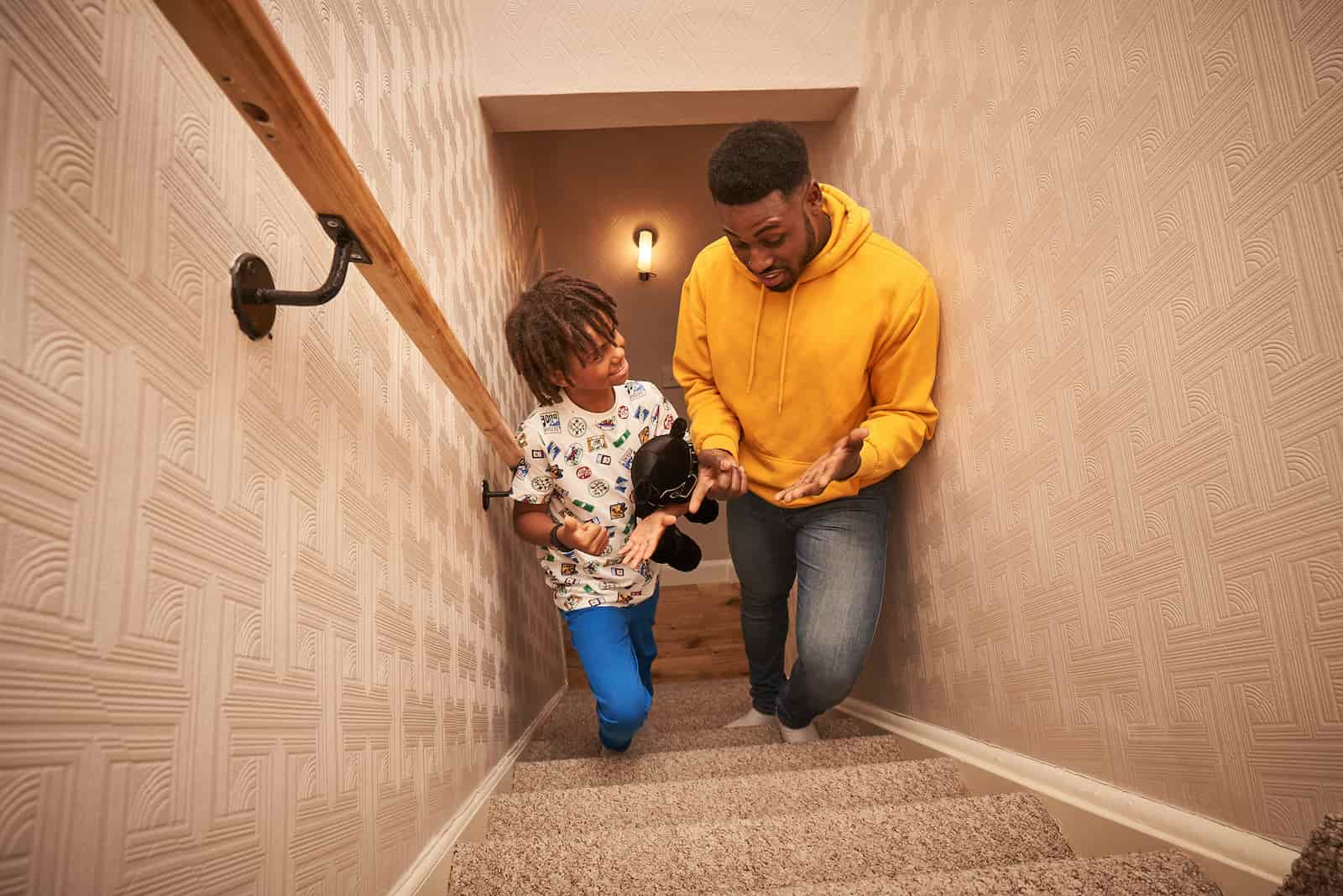 Image of a dad and child walking up a set of stairs together.