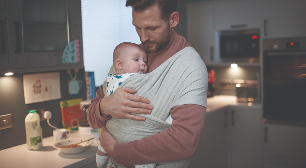 Photo of a dad holding his baby in a kitchen 