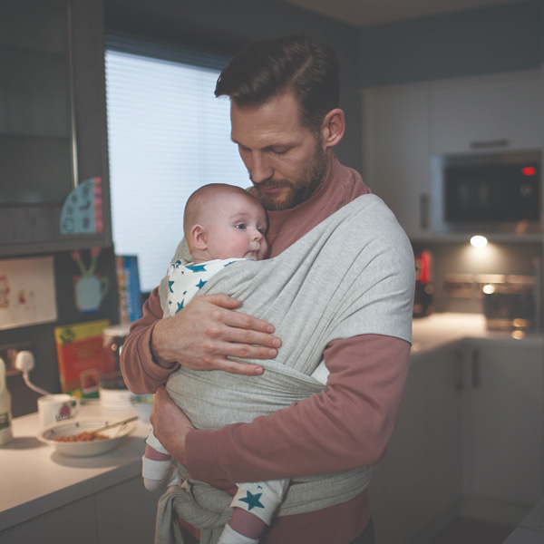 Photo of a dad holding his baby in a kitchen 
