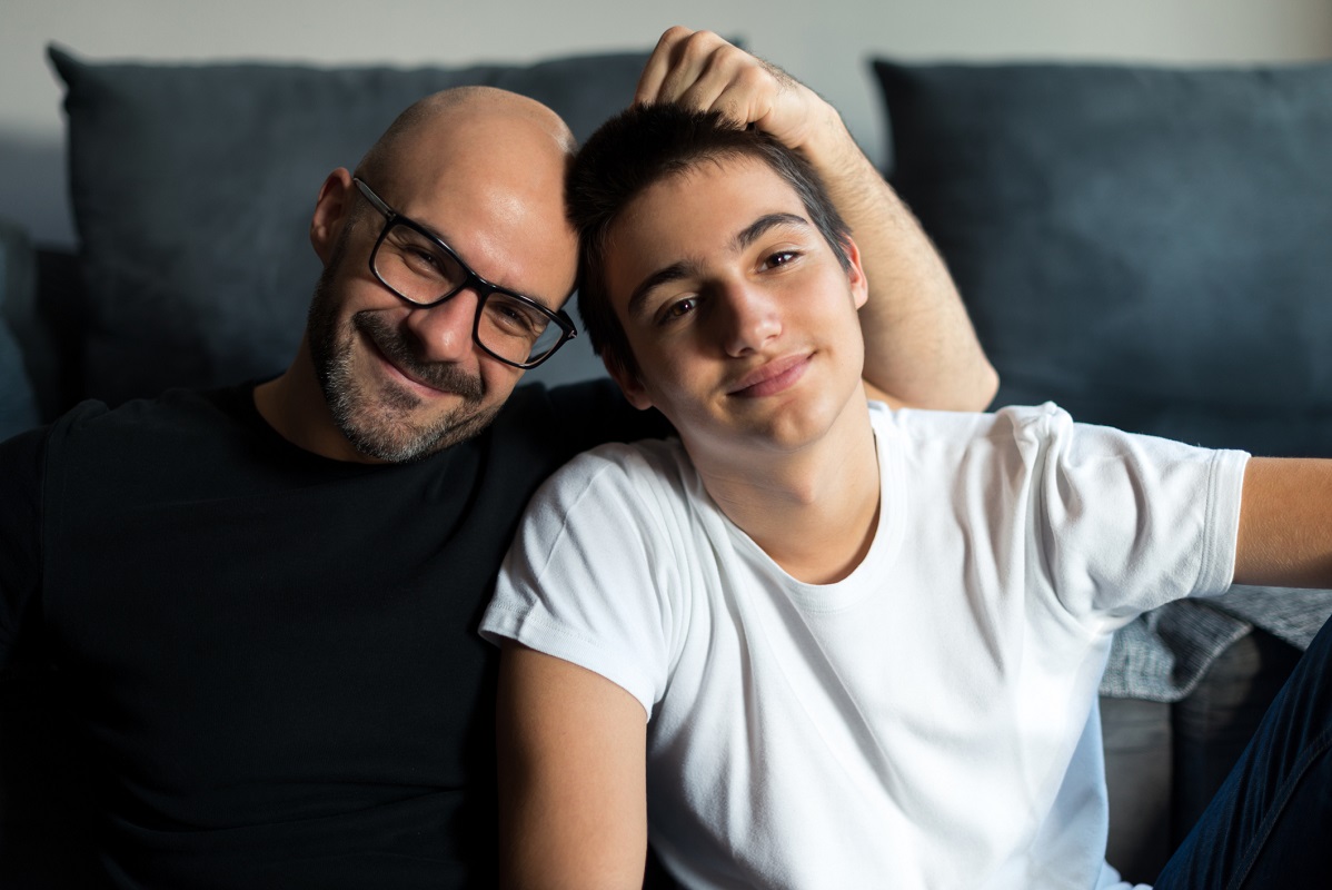 Dad and teen son smiling