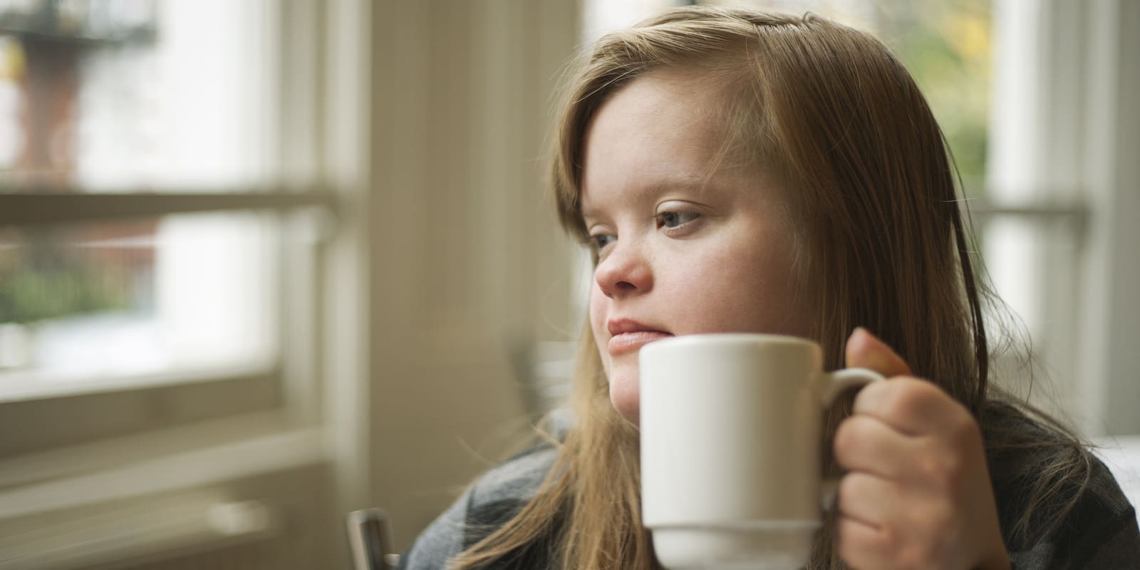 Down syndrome girl having breakfast drink