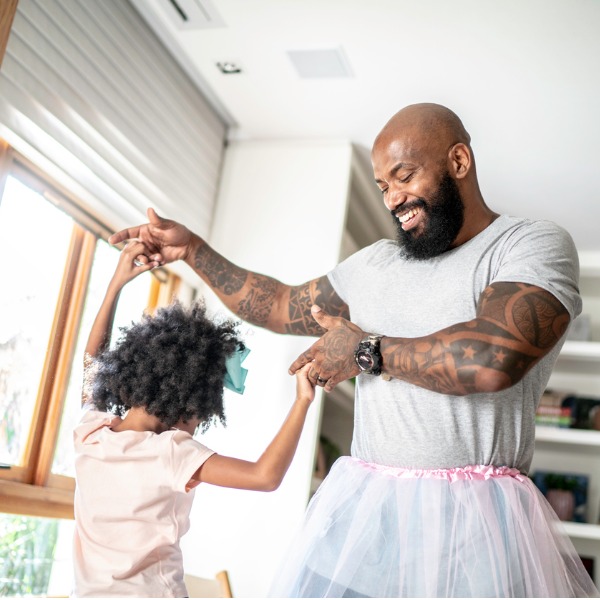 Father wearing a tutu dancing with his daughter