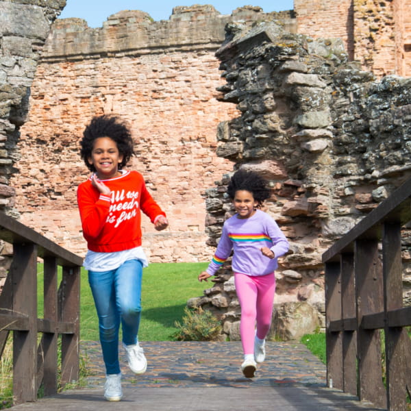 Photo of girls running in a castle courtyard 