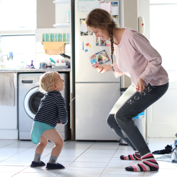 Image of a mum and a toddler dancing together in a kitchen.