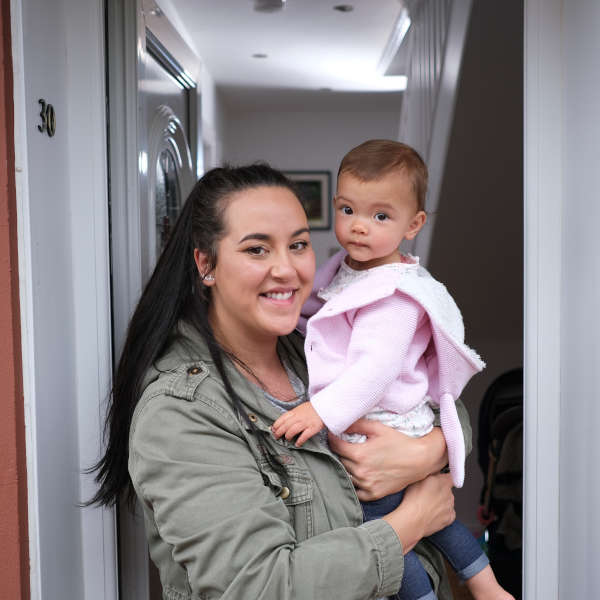 Photo of a mum holding her baby in a doorway 