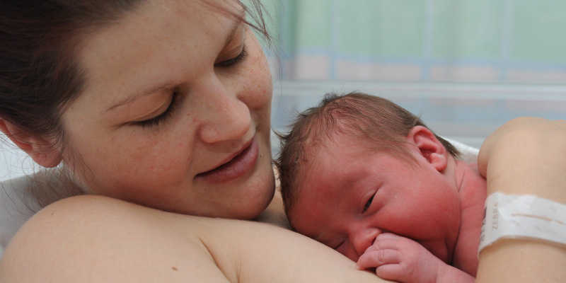 Image of a mum holding her newborn baby in hospital.