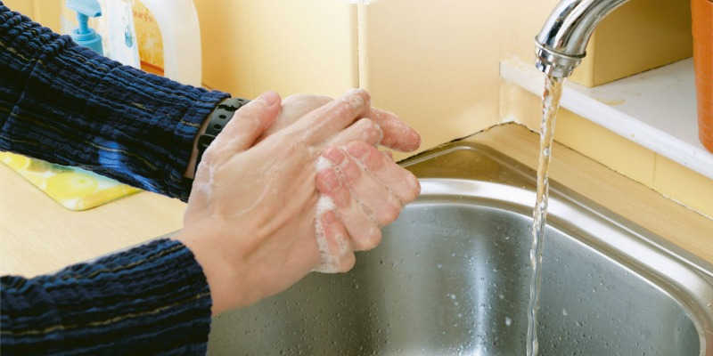 Photo of a person washing their hands in the sink