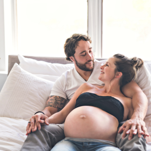 Photo of a pregnant couple relaxing in bed