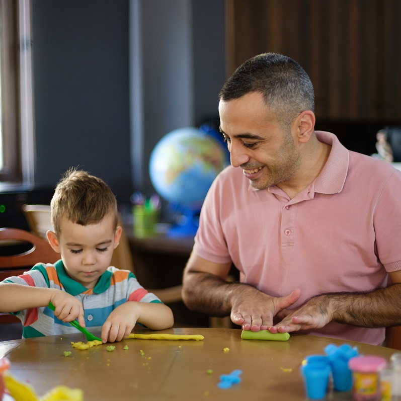 3 year old child and dad playing with play dough