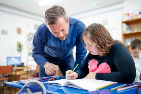 Teacher and student with Down's syndrome looking at school work