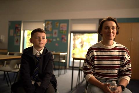 Boy and his mother in a school classroom.