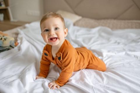 Cute baby on a bed.