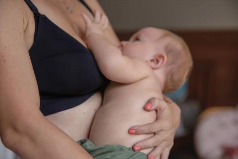 Mum wearing a black breastfeeding bra, holding her baby.