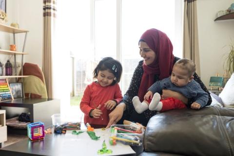Mum wearing a hijab, with her toddler and baby.