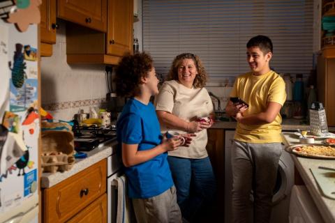 Mother and two boys chatting in their kitchen.