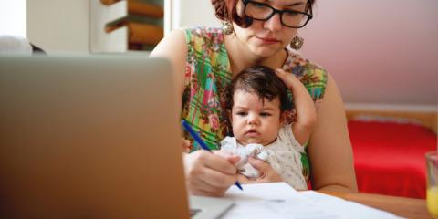 Photo of mum at laptop with baby in lap 
