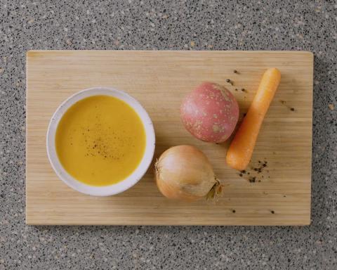 Bowl of carrot soup with ingredients