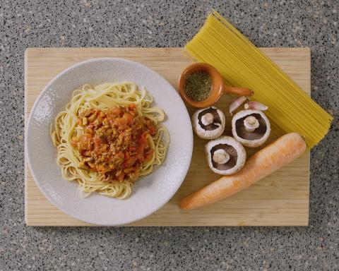 Bowl of spaghetti bolognese with ingredients