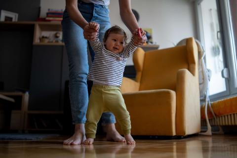 Photo of a mum helping baby to walk 