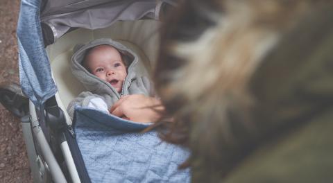 Photo of a happy baby smiling up at their mum 