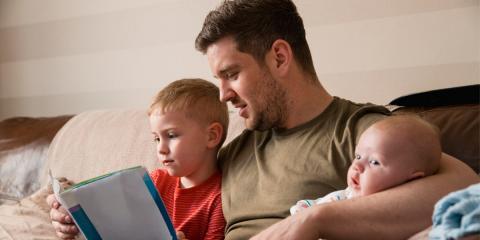 Photo of a dad reading to his kids 
